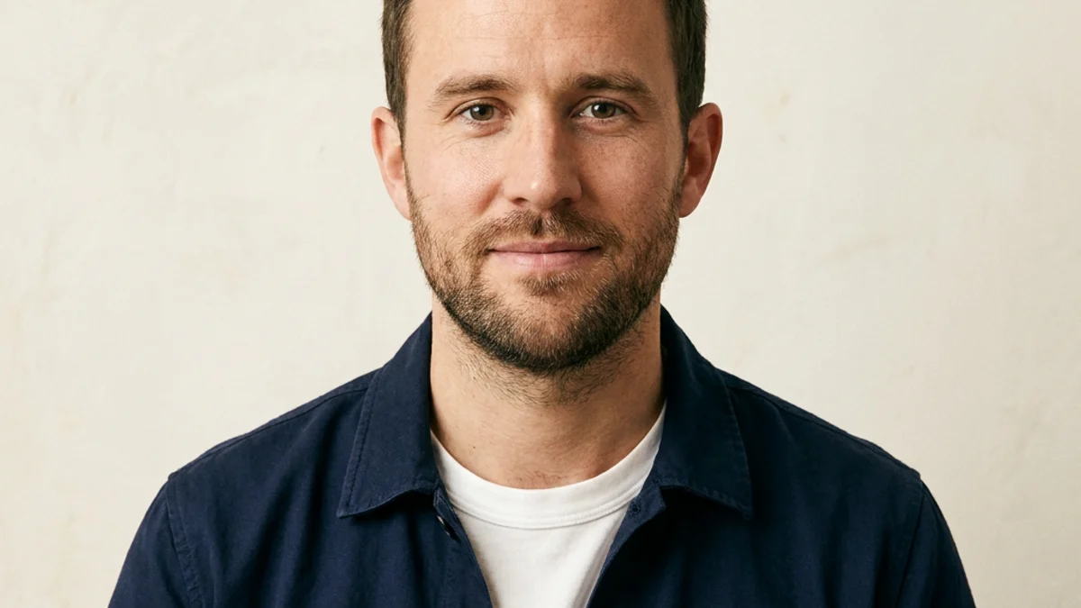 Professional profile picture of a male product designer in a navy overshirt